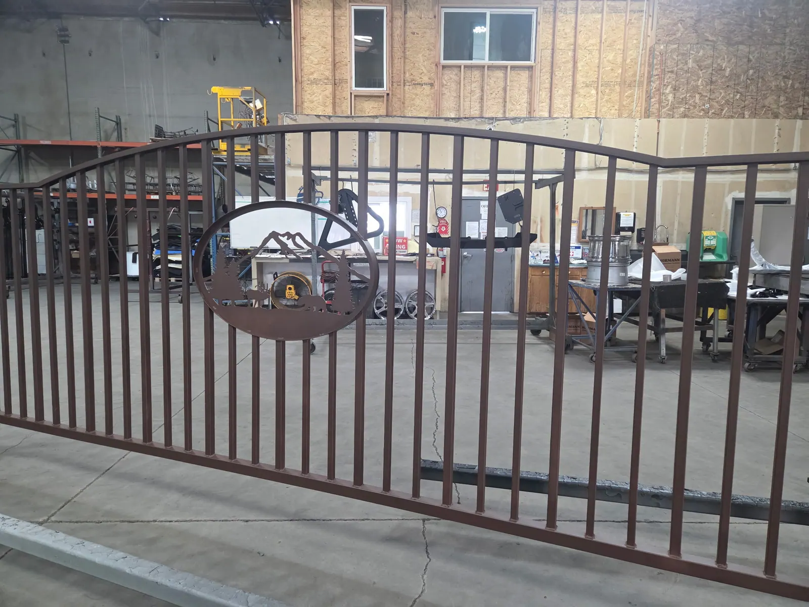 Finished metal gate panel with a decorative circular accent.