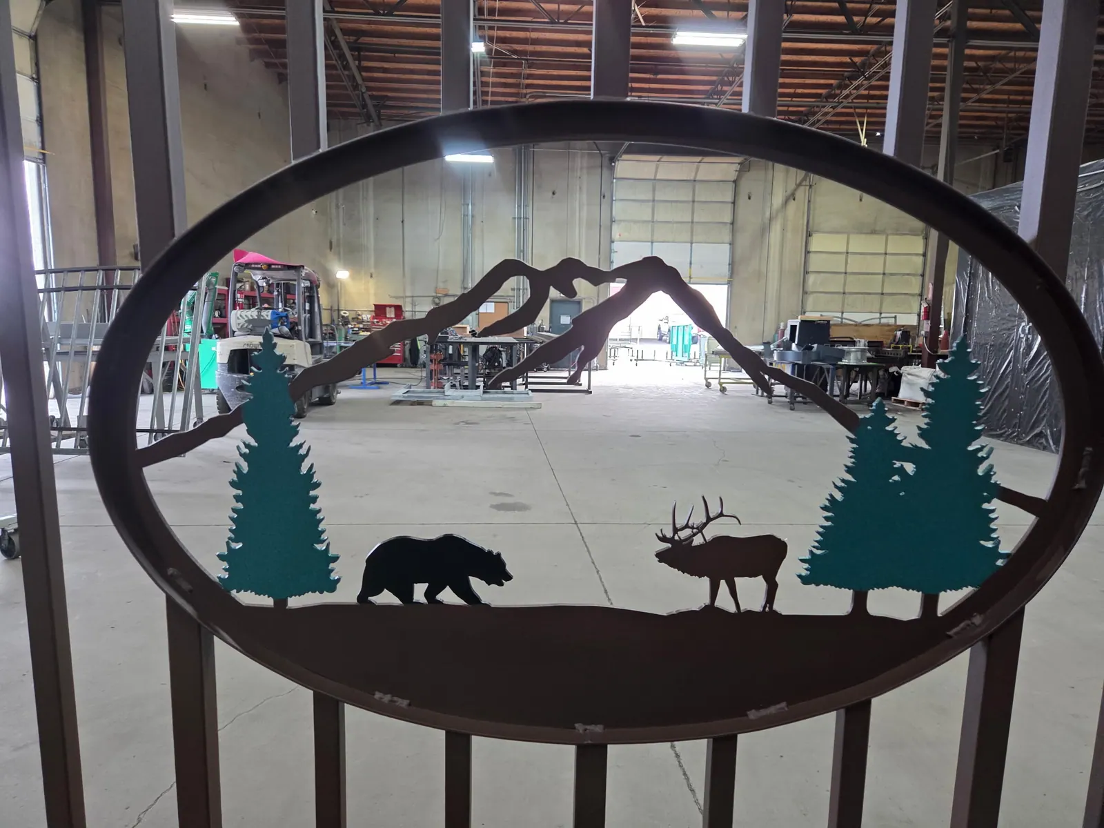 Decorative oval metal sign with powder coated wildlife cutouts.