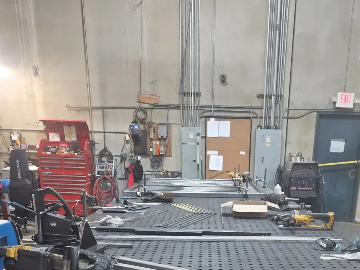 Steel fabrication table with metal components staged for shop work.